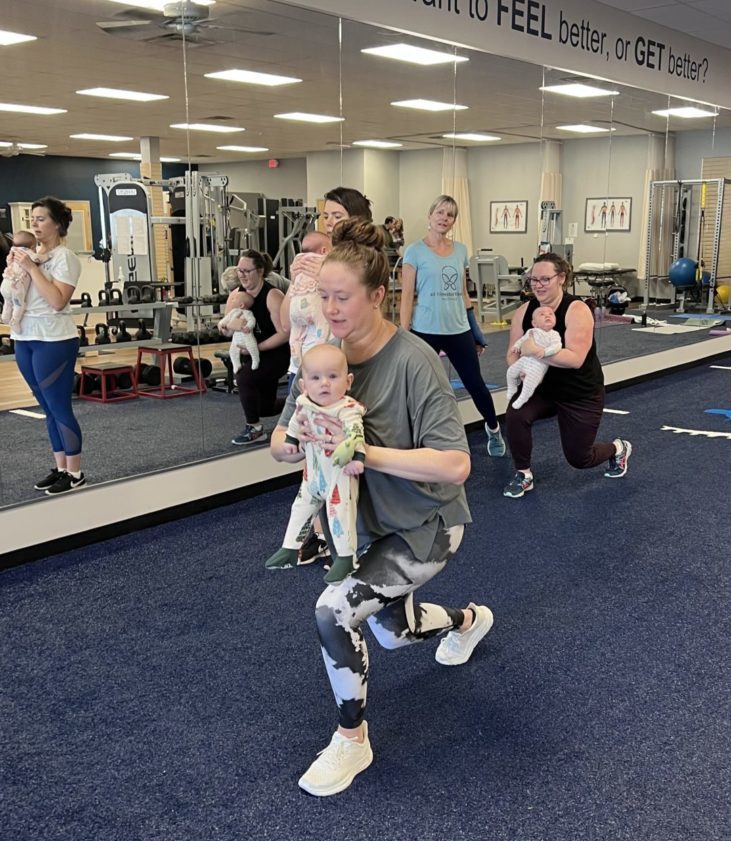 Mothers participate in lunge workouts with their newborns.